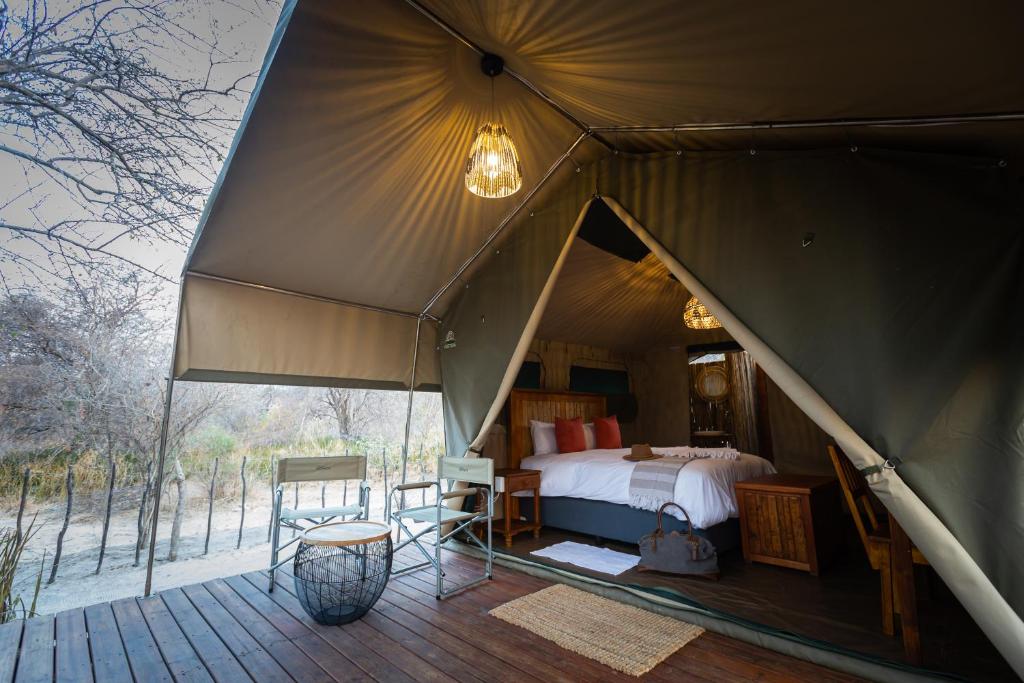 马翁Boteti Tented Safari Lodge的一个带床和甲板的大型帐篷