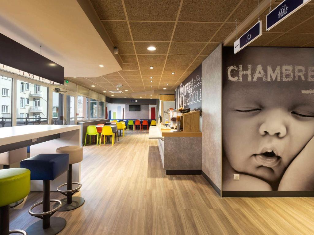 布尔昆Ibis Budget Bourgoin Jallieu Centre的墙上有婴儿脸的餐厅
