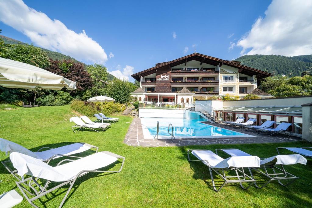 巴德小基希海姆松纳尔姆酒店的一个带游泳池和椅子的度假胜地和一座建筑