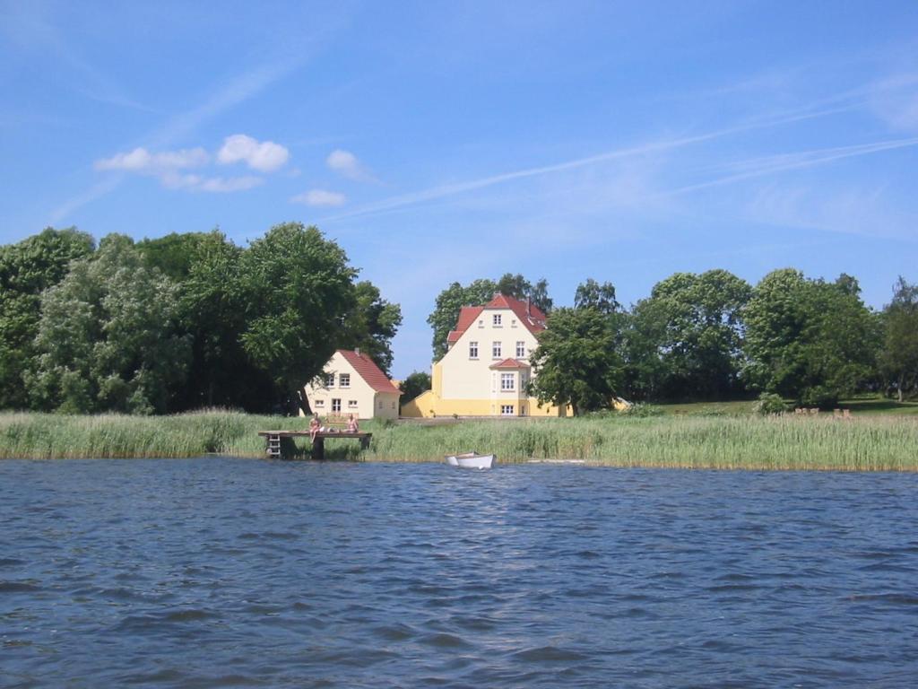 NeuenkirchenFerienwohnung 6 WLAN Sauna Wasserblick的水体岸边的房子