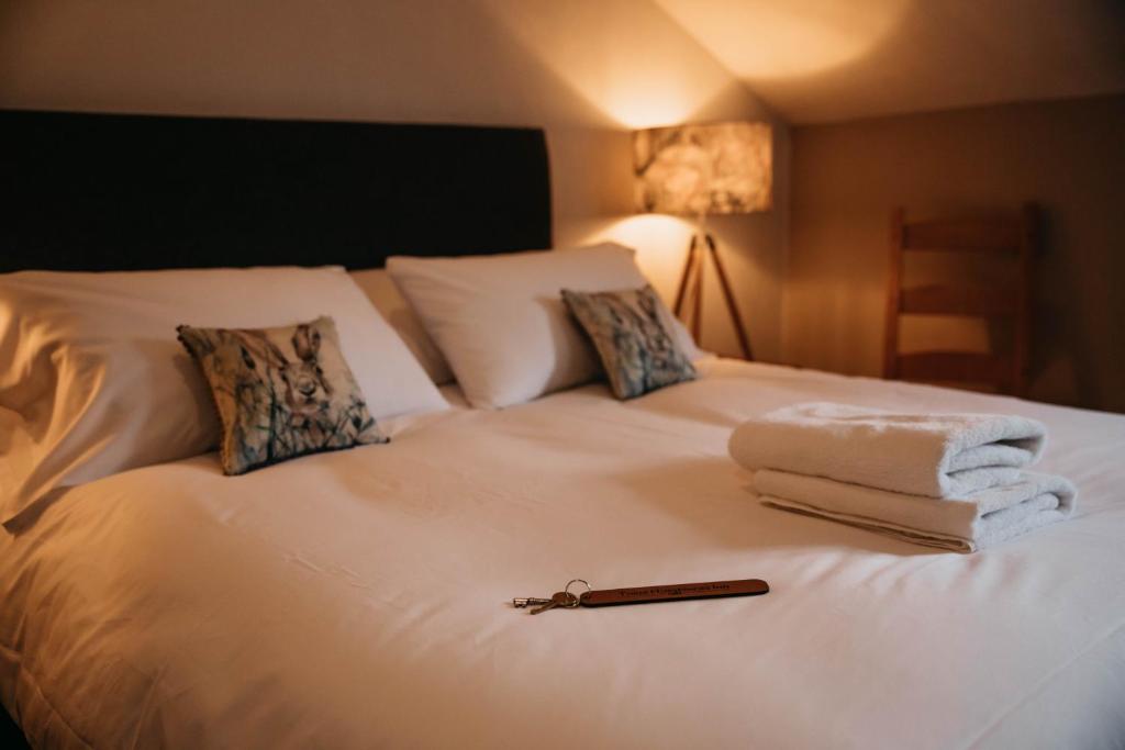 赫里福德三马蹄旅馆的一张带毛巾的白色床和一本书