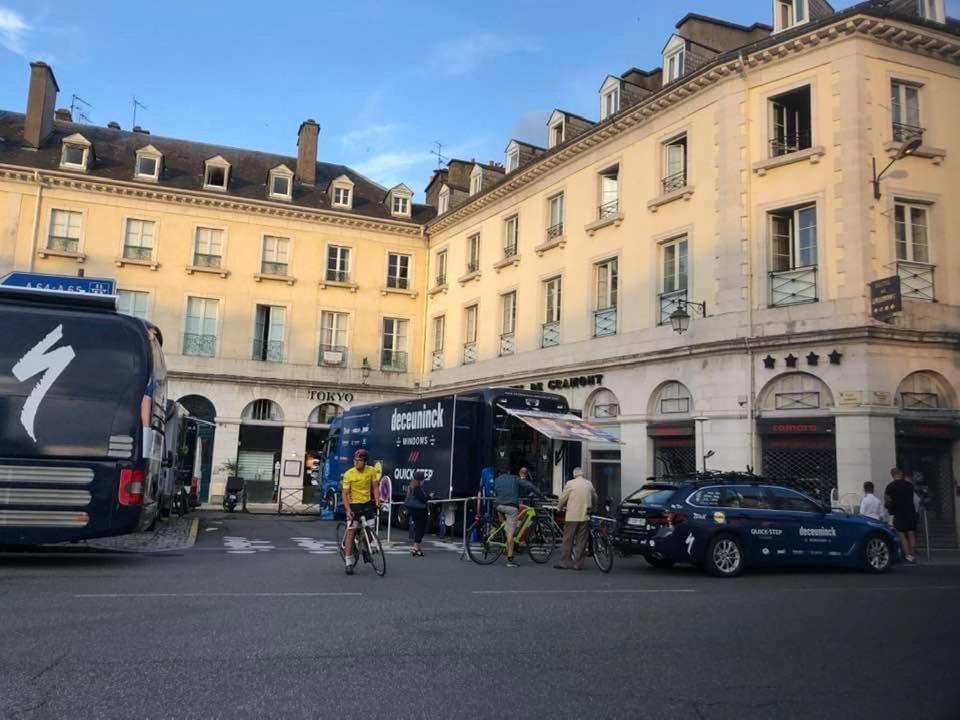 波城Hotel De Gramont的一群人骑着自行车在街上骑着一辆公共汽车