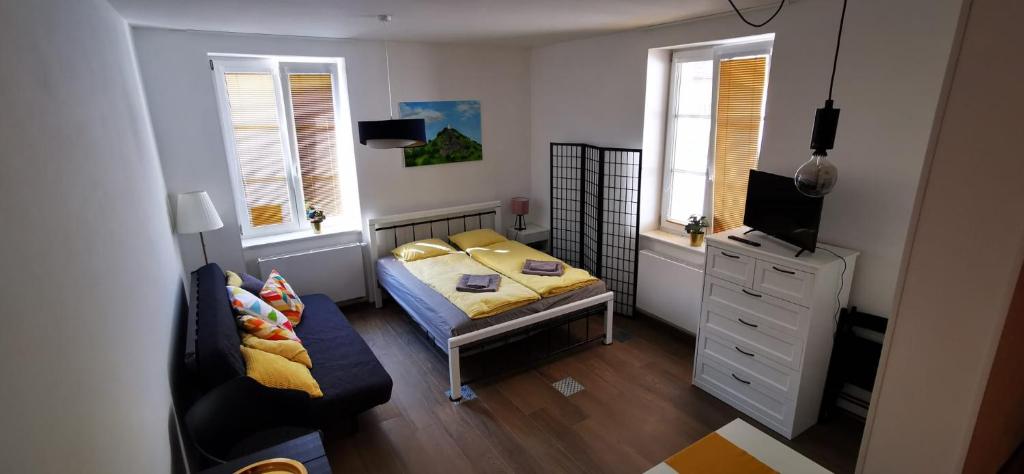 伊钦Apartmán Augustin Jičín的一间带床和沙发的小卧室