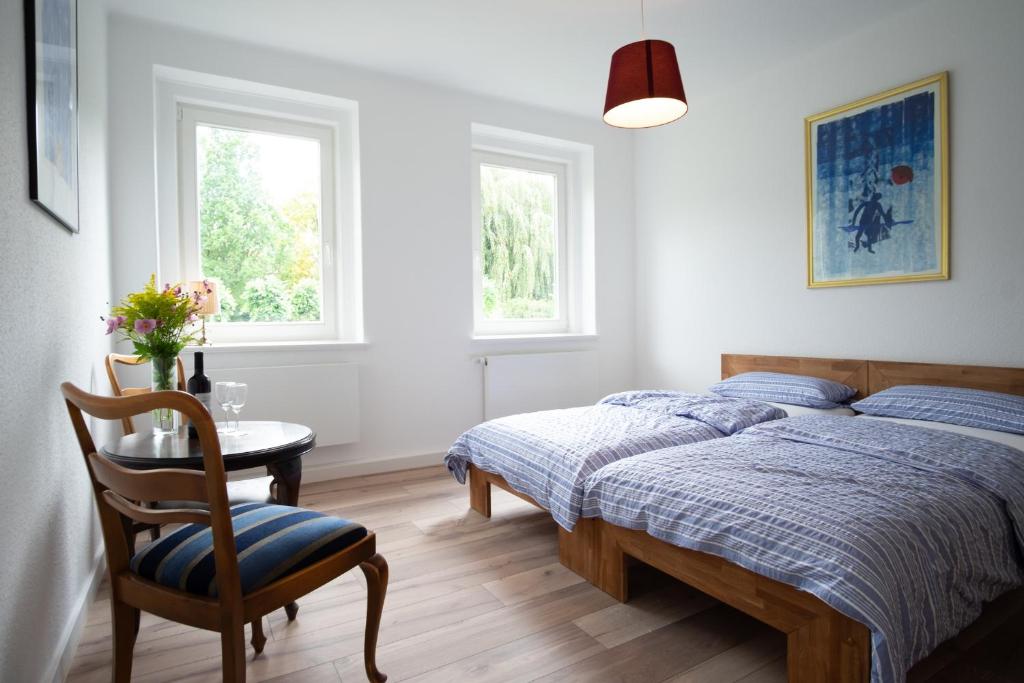 戈斯拉尔Altstadt Apartment的一间卧室配有一张床、一张桌子和两个窗户