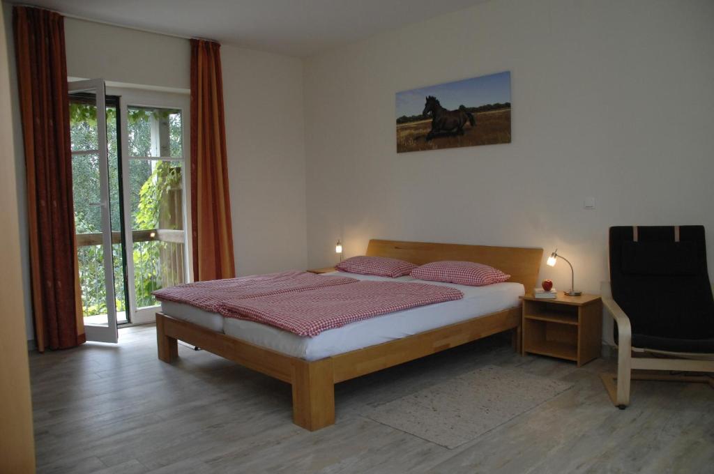 Neu KlockenhagenFerienwohnung "Westfalen"的卧室配有床、椅子和窗户。