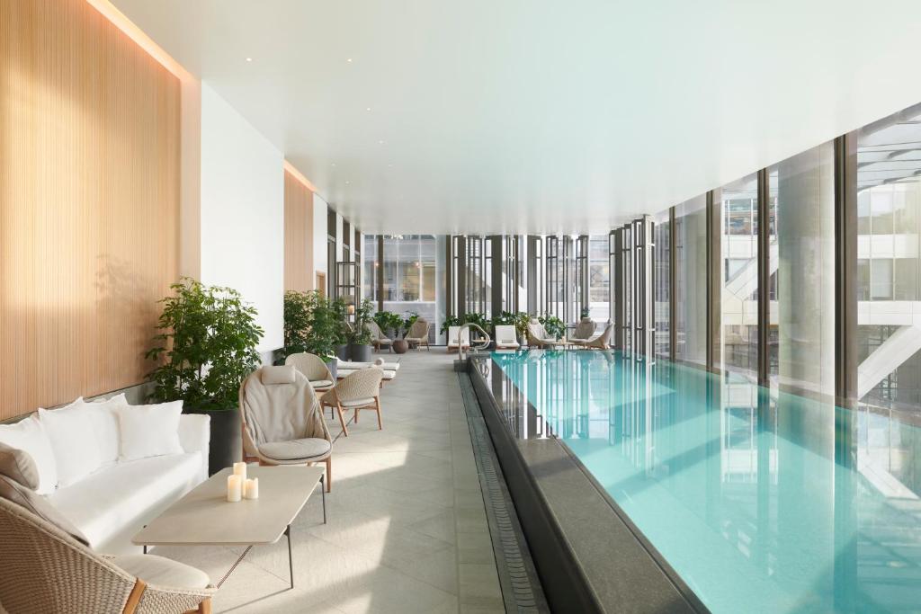 伦敦伦敦泛太平洋酒店的一座带椅子的建筑中央游泳池