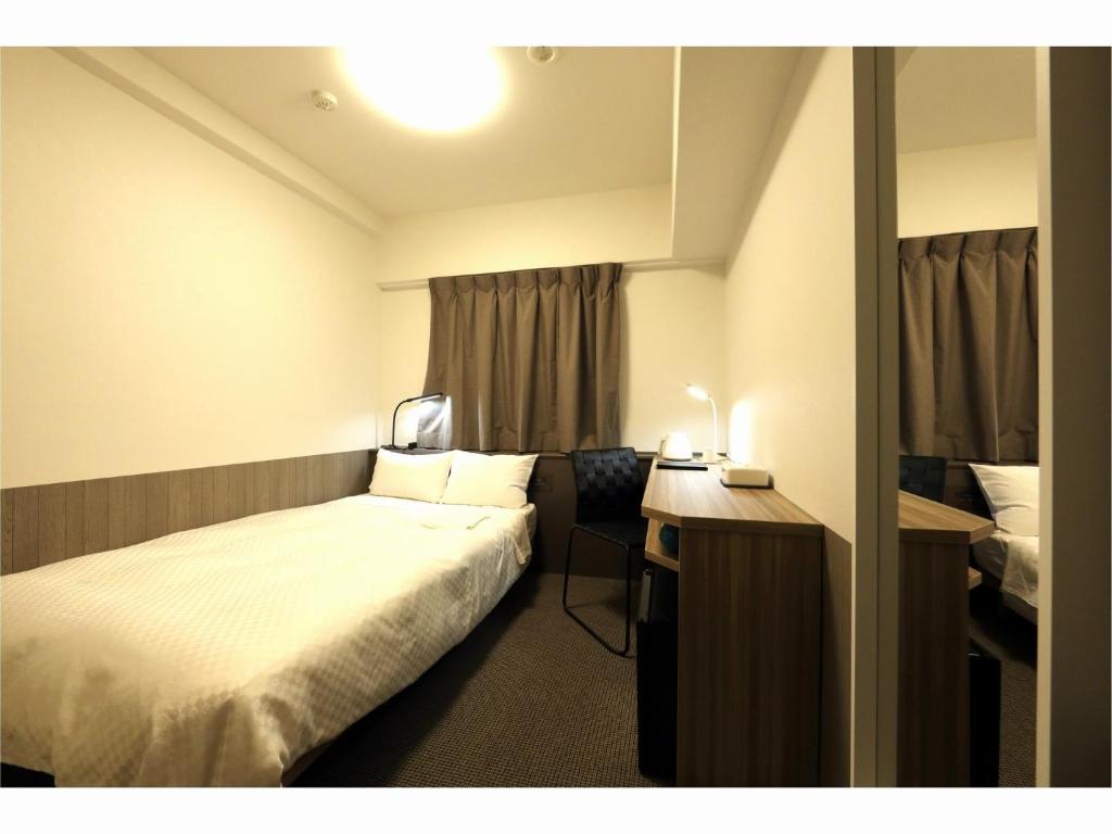 仙台Sendai Business Hotel Ekimae - Vacation STAY 71937v的配有一张床和一张书桌的酒店客房
