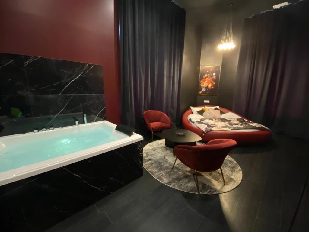马孔Legend Majestic Superbe Love Room - Jacuzzi - Champagne - Romantisme - parking privé的带浴缸的浴室和1间带1张床的卧室