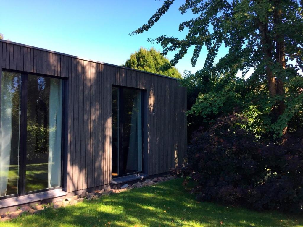 埃肯弗德Ferienhaus HL 23的院子里设有玻璃门的黑色房子