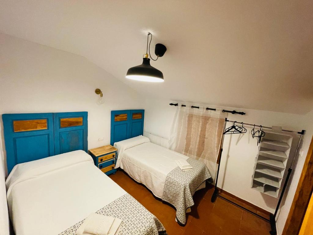 科特里奥斯努瓦斯Albergue Hospedería Montaña Morciguillinas的一间卧室配有两张床和一盏灯