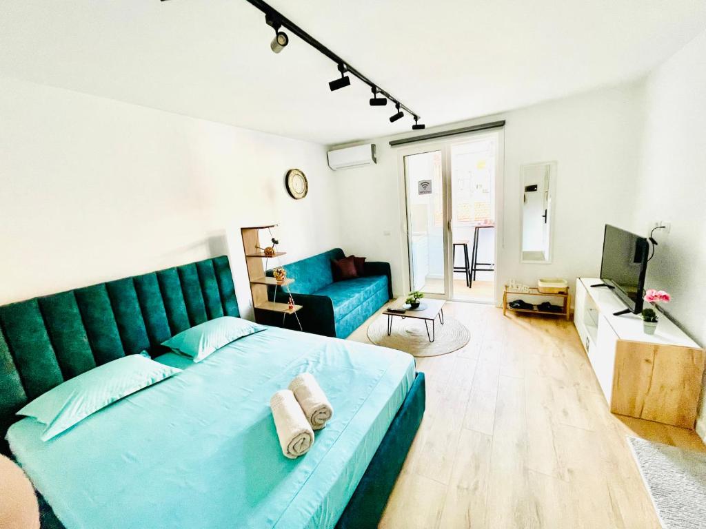 地拉那Central Studio Apartment 1, Tirana的一间卧室配有蓝色的床和蓝色的沙发