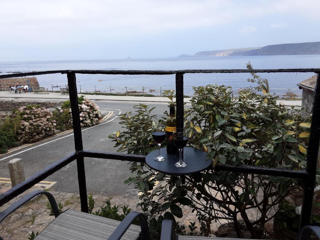 森嫩湾Sennen Cove Retreat的阳台上的桌子和两杯葡萄酒