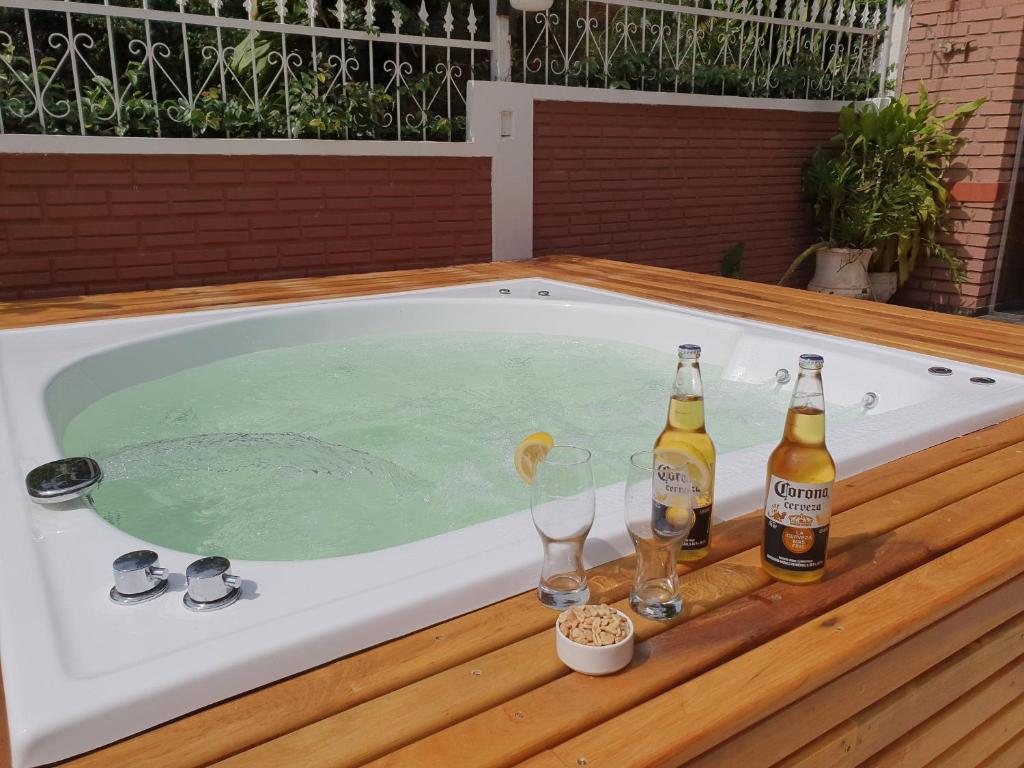 伊瓜苏港Hotel AATRAC Iguazú的热水浴池,提供2瓶啤酒和玻璃杯