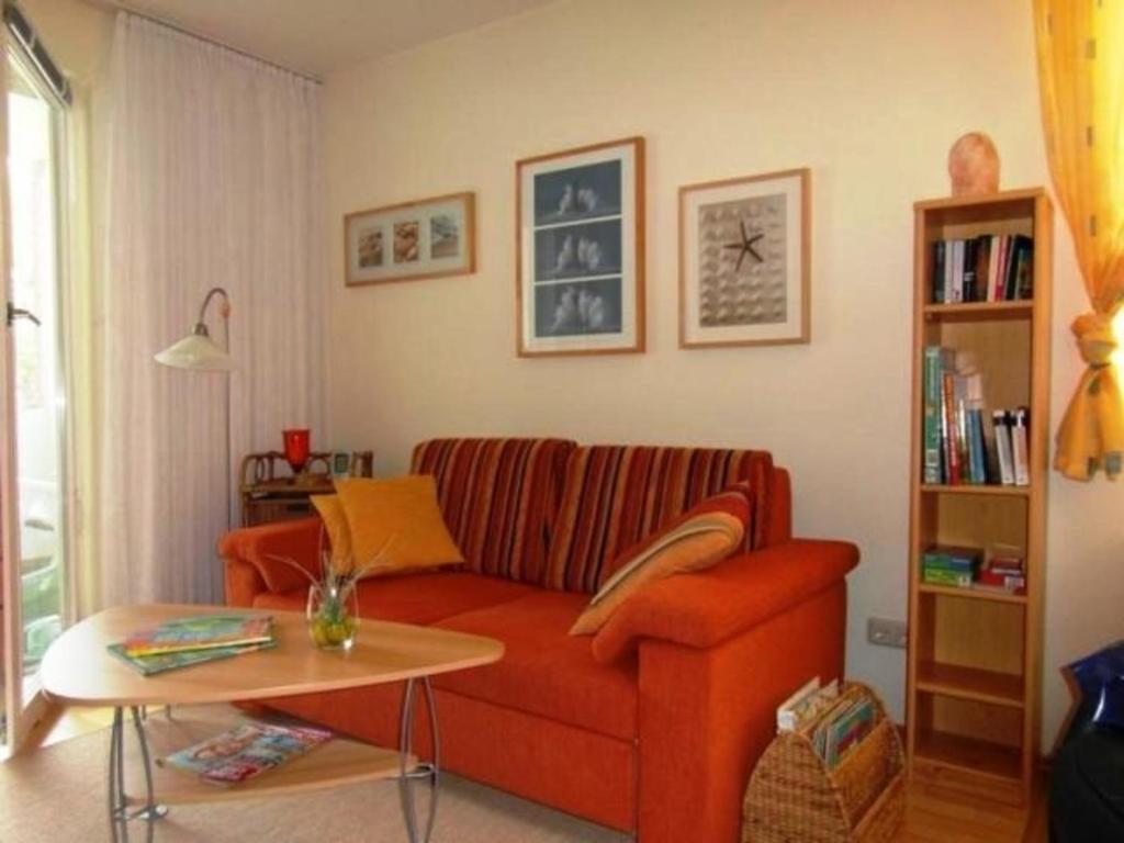 布尔哈沃Fewo 91 WHG B 18 in Burhave的客厅配有红色的沙发和桌子