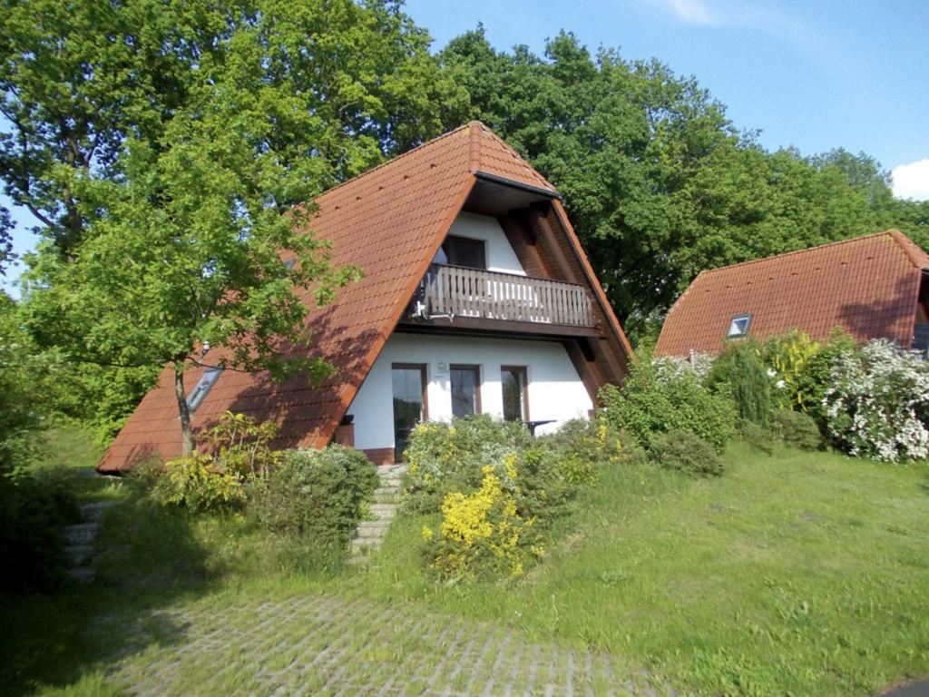 马尔洛Finnhäuser am Vogelpark - Haus Annika的庭院顶部有棕色屋顶的房子