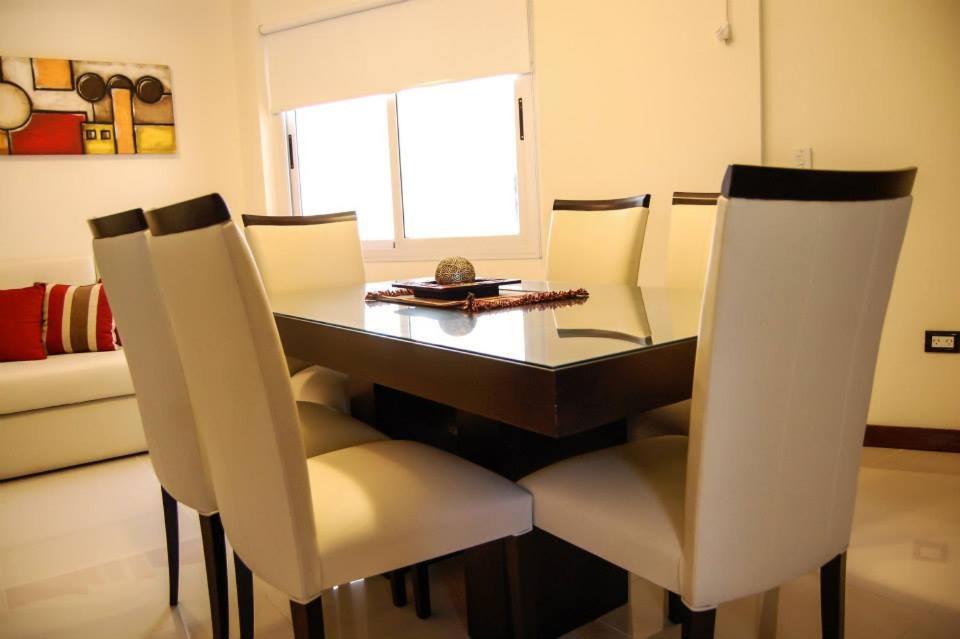 维拉卡洛斯帕兹Departamentos Premium Miralejos 3的一间带桌子和白色椅子的用餐室