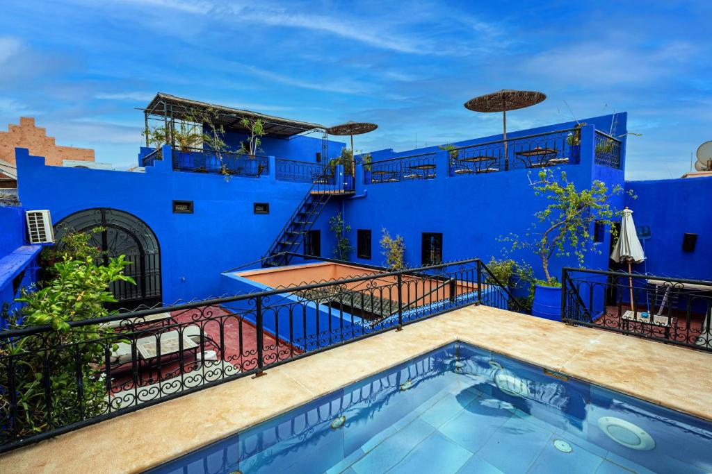 马拉喀什Riad ViewPoint的一座拥有蓝色墙壁和游泳池的房子