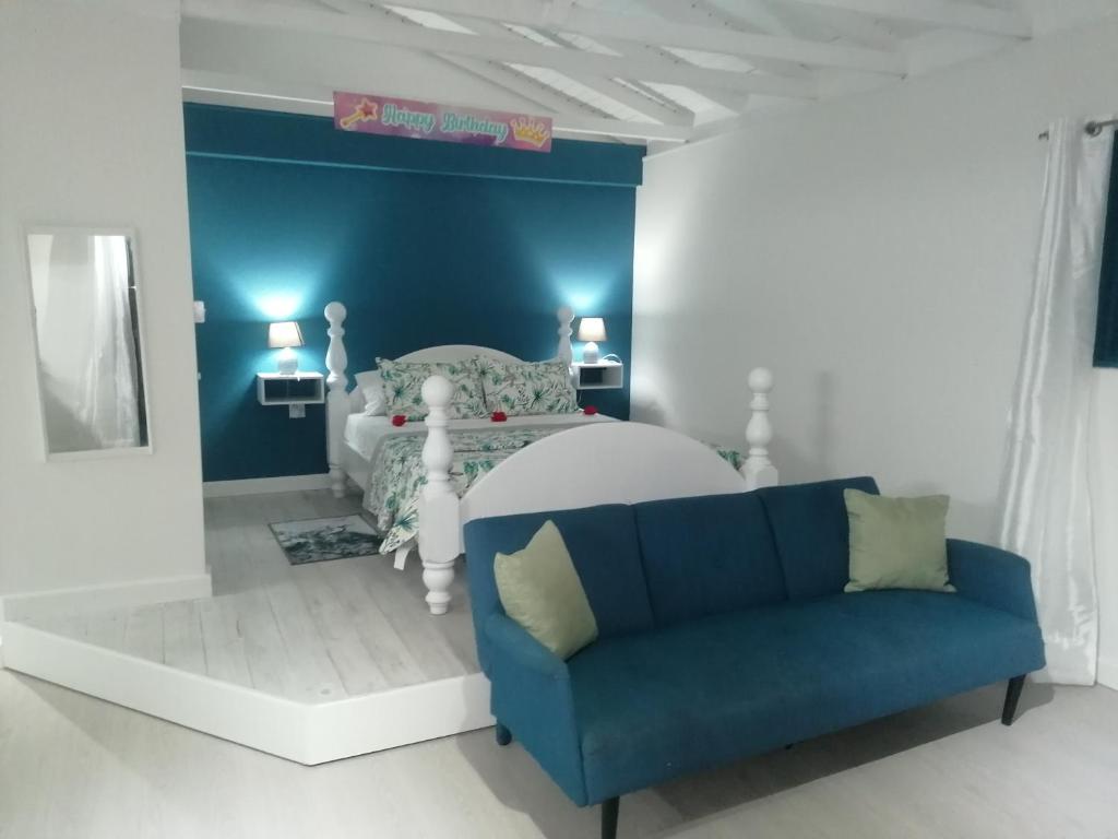 卡斯特里维加天堂小宁静旅馆的蓝色和白色的卧室,配有床和沙发
