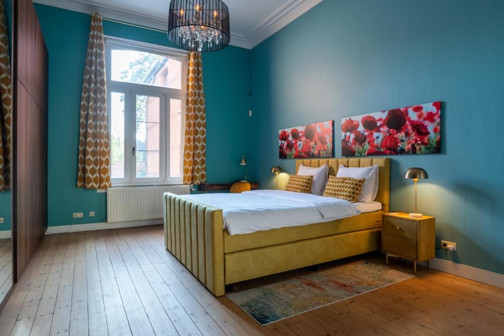 安特卫普Garden of Eden的一间卧室配有一张蓝色墙壁的床和一扇窗户
