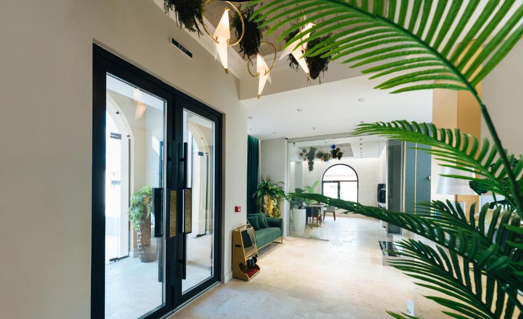 福克沙尼ARN Boutique Hotel的走廊上设有大玻璃门和植物
