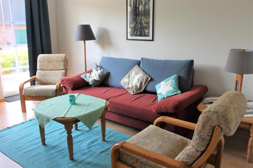 格洛米茨"Pappelhof - Whg 2"的客厅配有红色的沙发和椅子