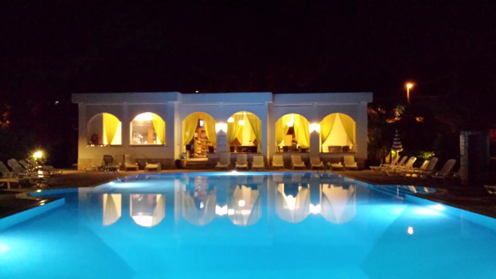 维耶斯泰Villaggio Alba Chiara的夜间大型游泳池,灯光照亮