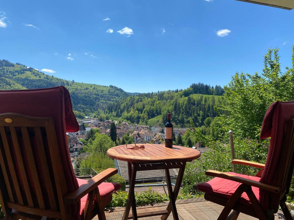黑林山区舍瑙Ferienwohnung Traumblick的庭院桌子上摆放着一瓶葡萄酒