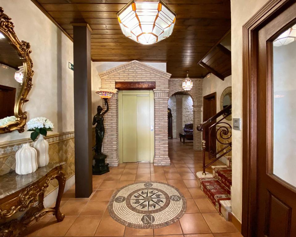 格拉纳达罗德里旅馆的走廊设有瓷砖地板和带吊灯的天花板