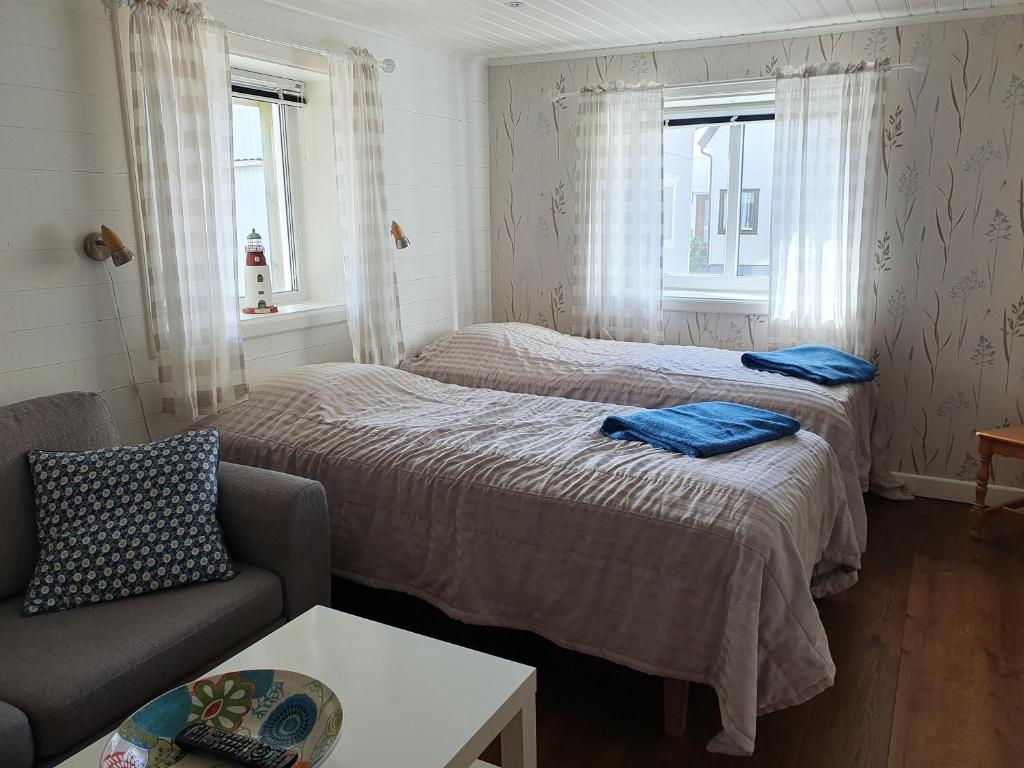 斯默根Nära Smögenbryggan的客房设有两张床、一张沙发和两个窗户。