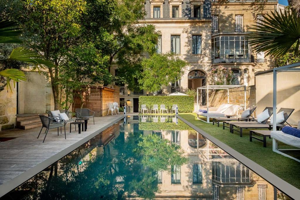 波尔多Le Palais Gallien Hôtel & Spa的建筑前带游泳池的庭院