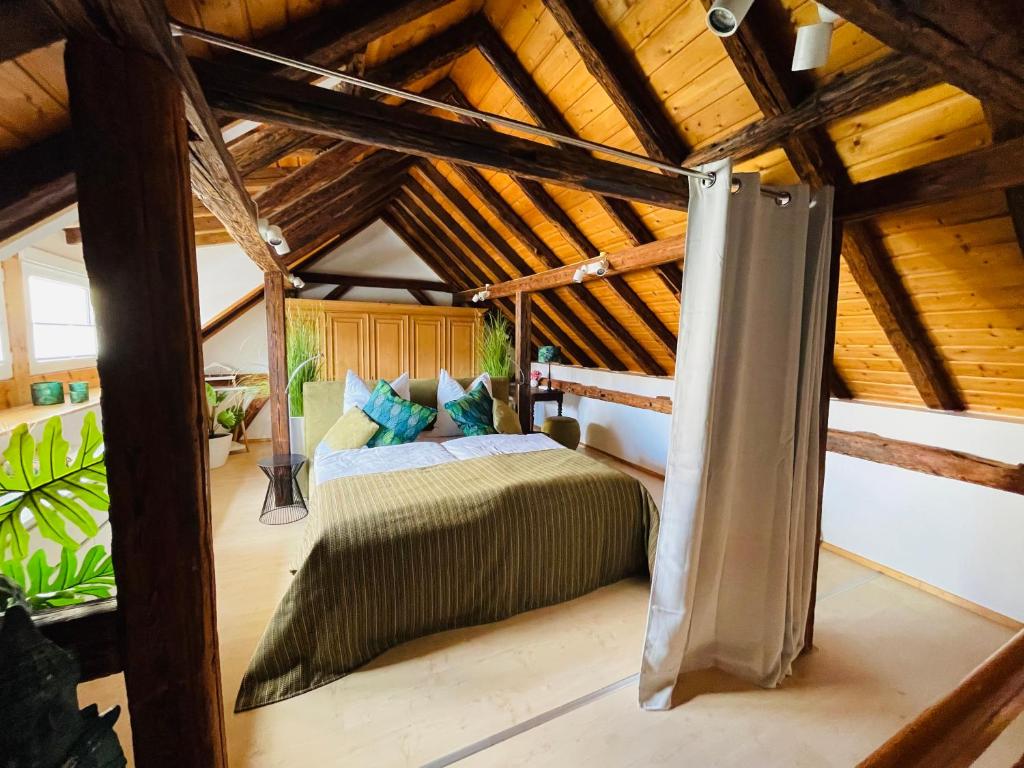 美因茨Ferienhaus Zur Hofreite的一间带一张床的卧室,位于带木制天花板的房间内