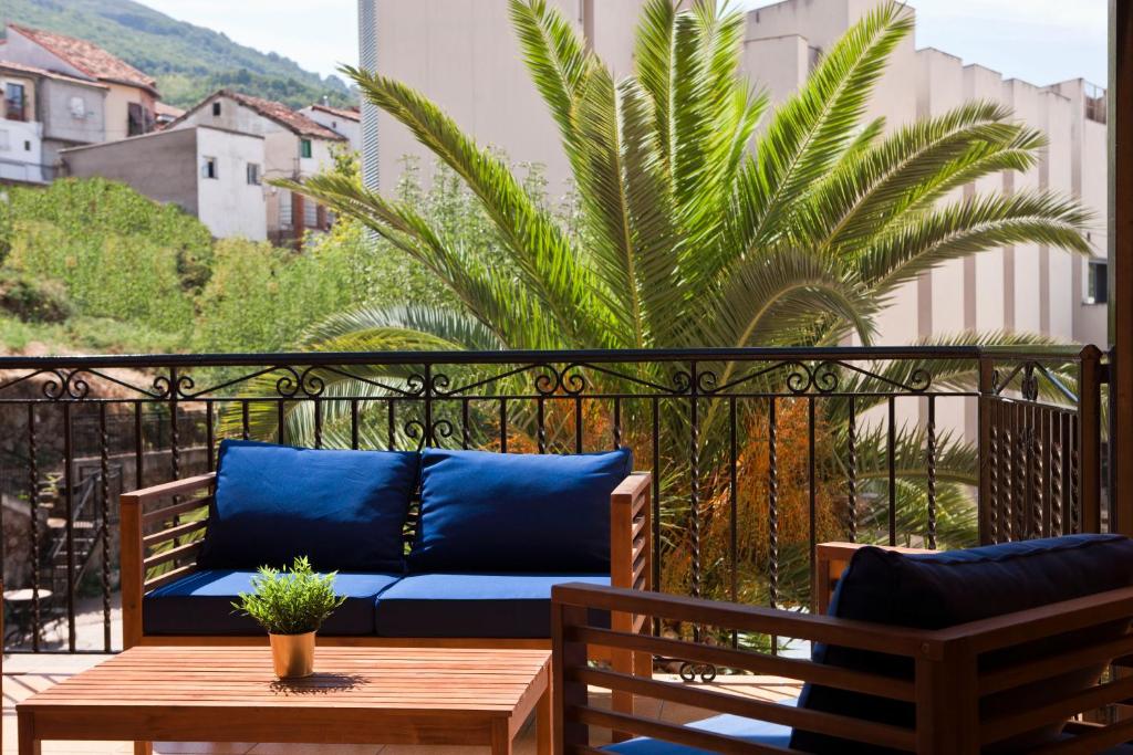 巴尼奥斯德蒙特迈奥尔Hotel Rural El Molino的棕榈树阳台的蓝色沙发