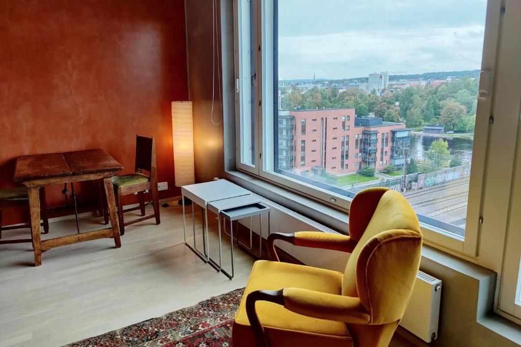 坦佩雷The Cutest Studio in Central Tampere的客房设有带椅子和书桌的大窗户。