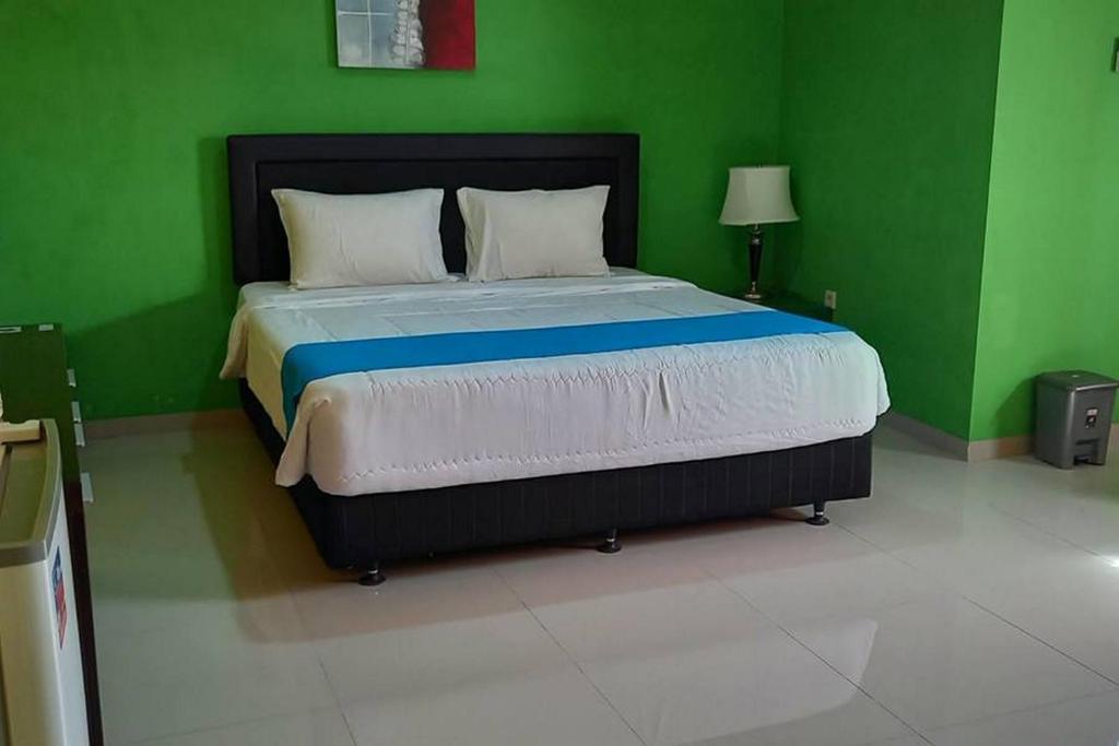 TjolomaduRedDoorz near Bandara Adi Soemarmo Solo的一间绿色卧室,在客房内配有一张大床