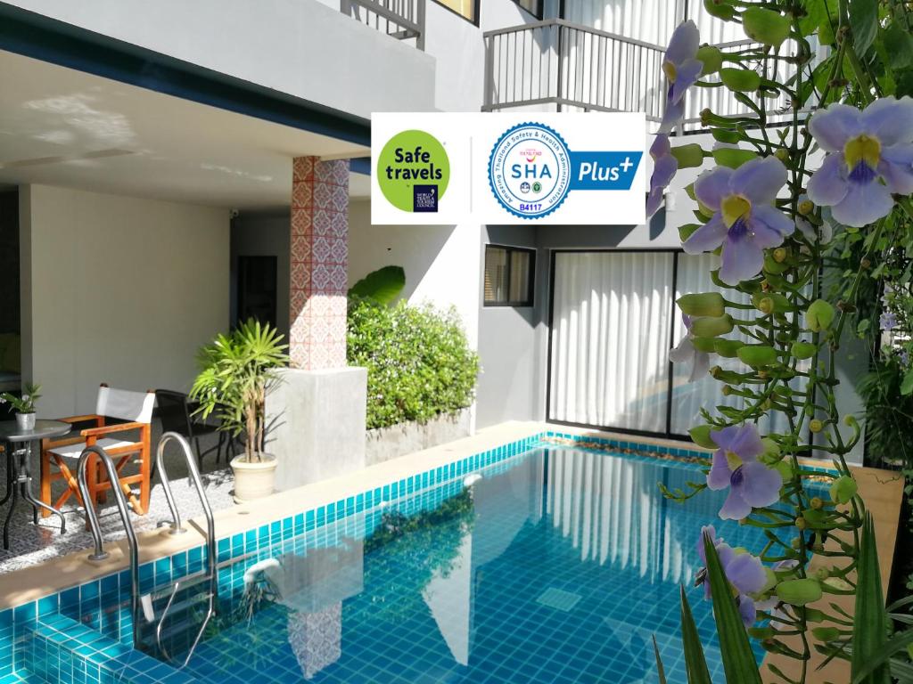 卡马拉海滩The Umbrella House - SHA Extra Plus的一座紫色花卉建筑旁边的游泳池