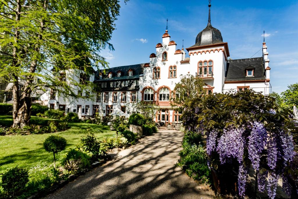 埃尔特维勒选帝侯大街酒店的一座带花园和紫色鲜花的古老豪宅