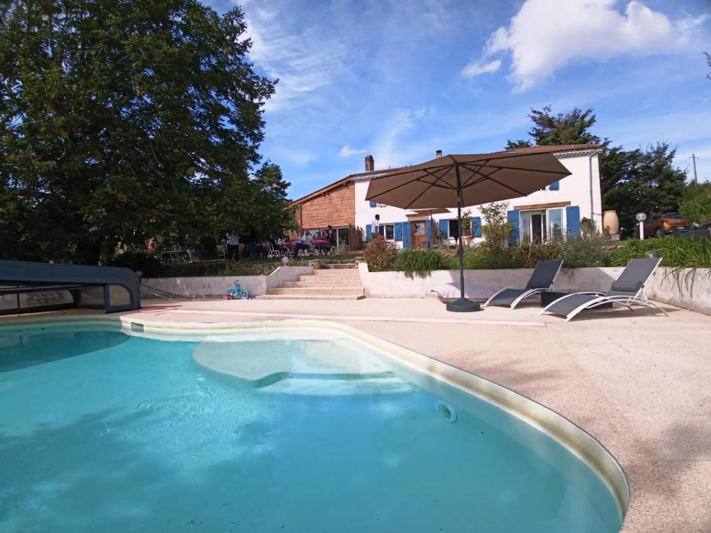 奥特里韦Les Gîtes de l'aiguete的一座房子旁带遮阳伞的游泳池