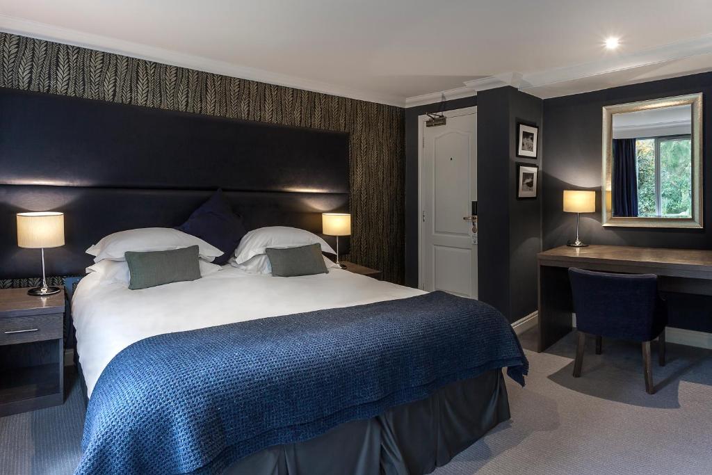 安布尔塞德兰代尔Spa酒店的一间卧室配有一张大床和一张书桌