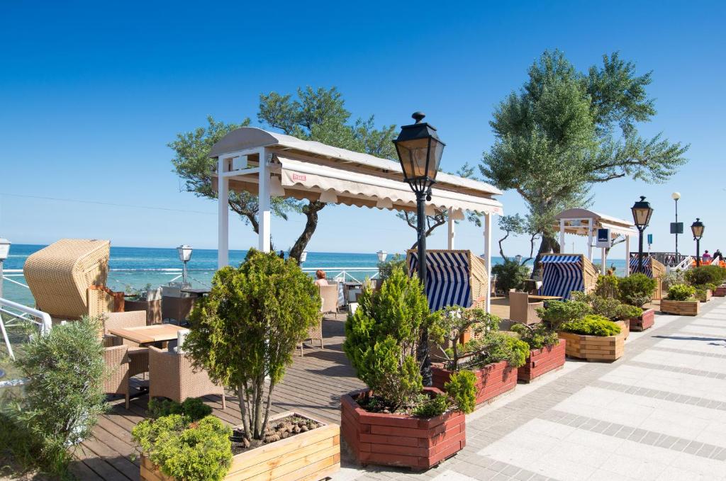 梅尔诺Meduza Hotel & Spa的一个带椅子和树木的庭院以及大海