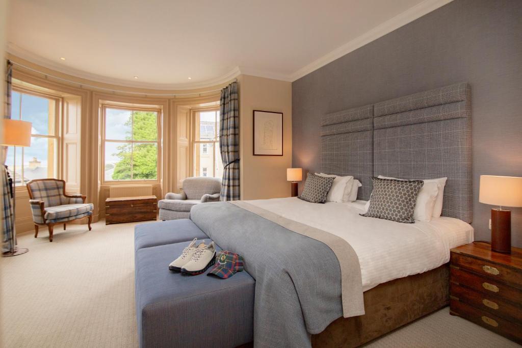 多诺赫皇家高尔夫酒店的一间卧室配有一张大床和一把椅子