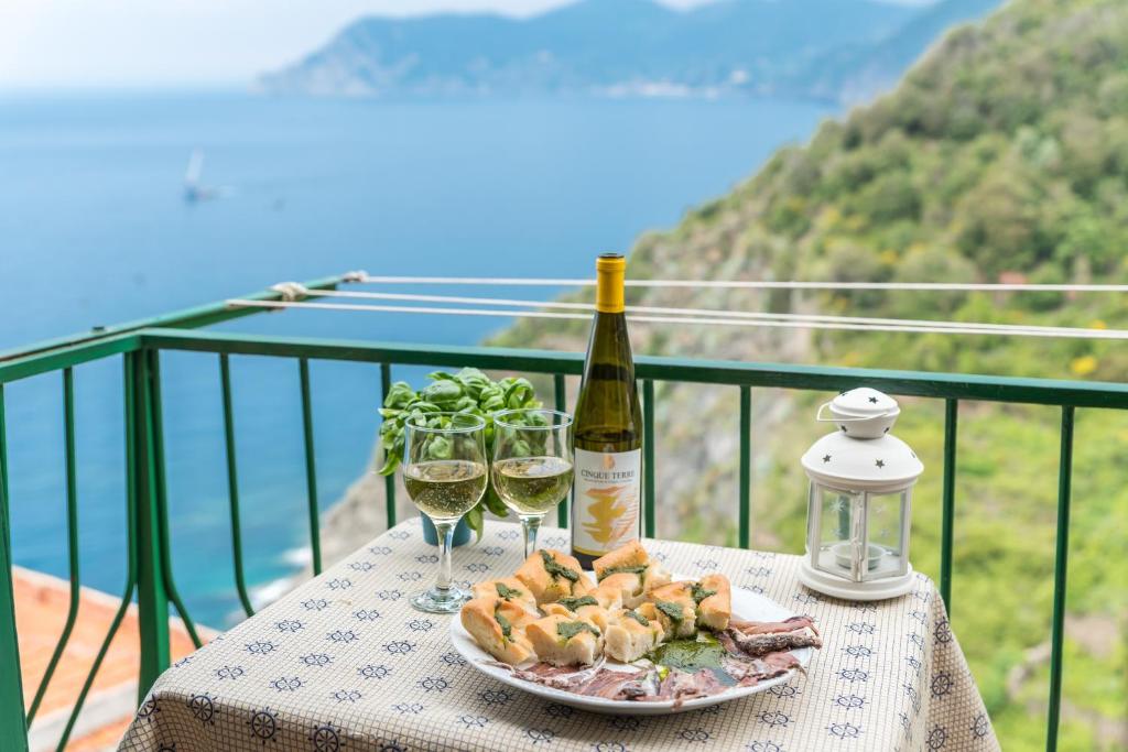 克里日亚Affittacamere Arbasia De Ma, Terre Marine的一张桌子,上面放着一盘食物和两杯葡萄酒
