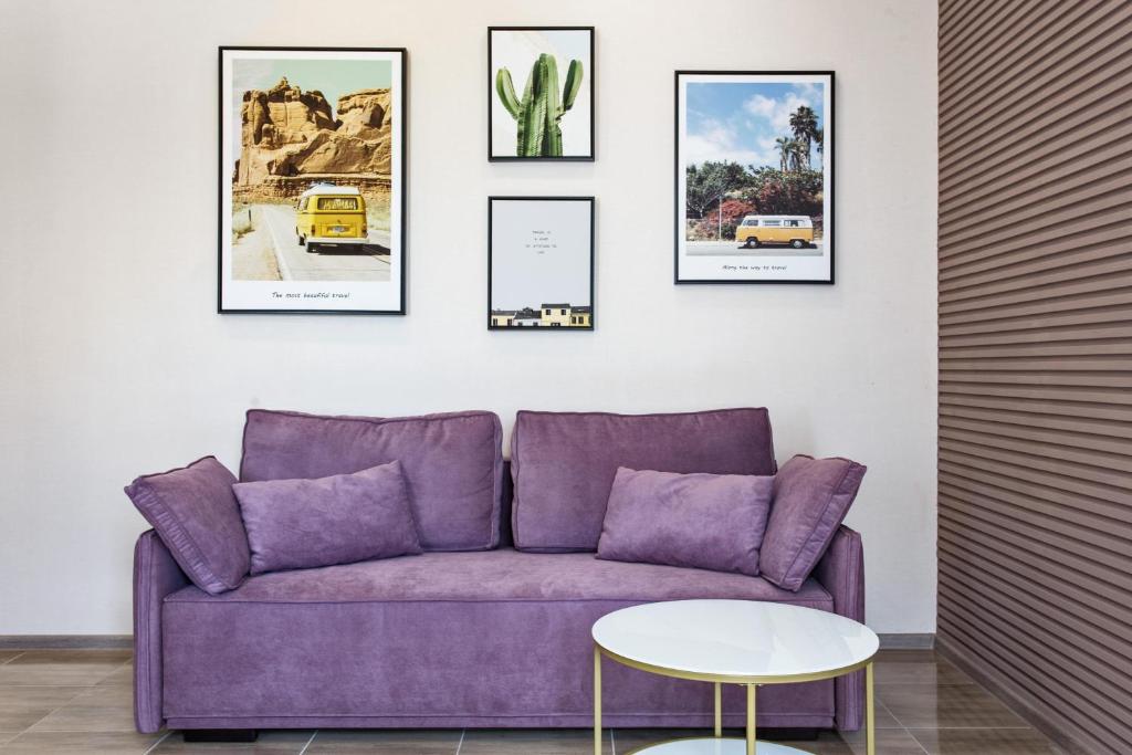 敖德萨Havana ApartHotel的墙上挂着照片的房间的紫色沙发