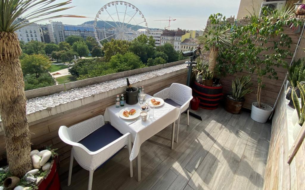布达佩斯维斯塔1-2公寓的阳台配有白色的桌椅和摩天轮