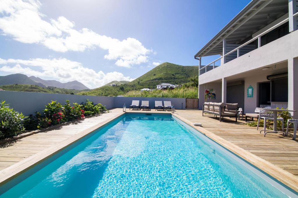 圣马丁岛Villa Jwi Lavi Boutique Hotel的一个带甲板和房子的游泳池