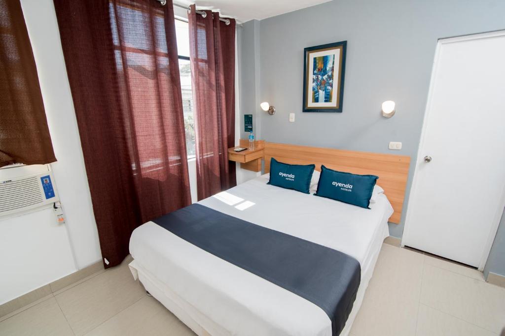 皮乌拉Ayenda Apart La Hacienda的一间卧室配有一张带蓝色枕头的大床