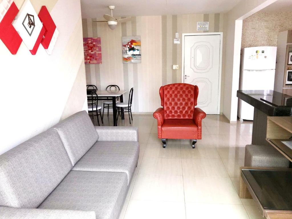 巴拉奈里奥-坎布里乌INCRÍVEL Ap a 100m do MAR com Ar e Wi-Fi的带沙发和红色椅子的客厅