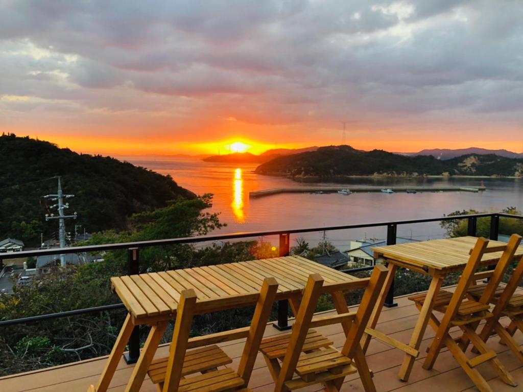 直岛町MY LODGE Naoshima的阳台的桌椅享有日落美景