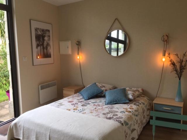 索米尔Chambre dans dépendance Maison de Ville + abri vélos的卧室配有一张床,墙上设有镜子