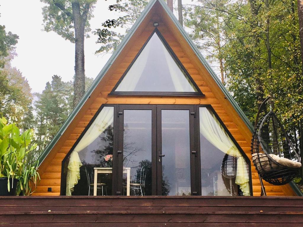 阿格洛纳Aleksandra Viesu Namiņš的一个带玻璃窗户的三角形屋顶框架小屋