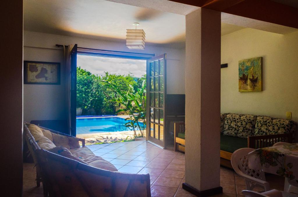 伊利亚贝拉Casa Ilhabela - melhor custo benefício的享有游泳池景致的客厅